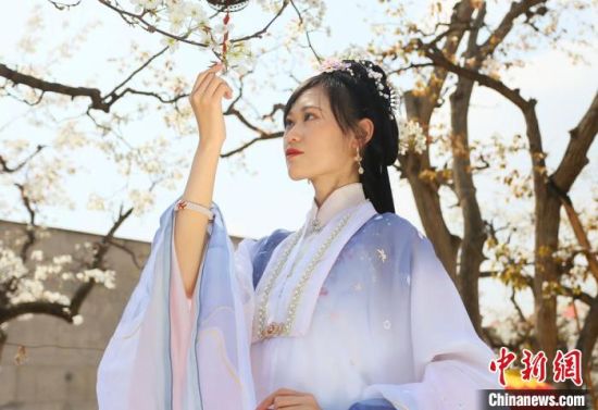 圖為蘭州青年身穿漢服在百年梨園賞景?！「哒?攝