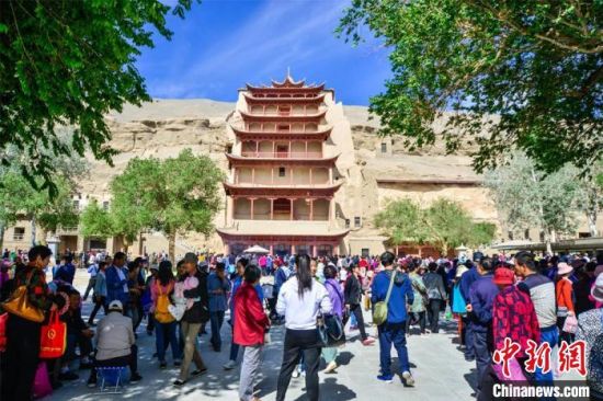 中國農(nóng)歷四月初八，敦煌民眾傳承歷史習(xí)俗，前往莫高窟燒香禮佛、祈福。(資料圖) 王斌銀 攝