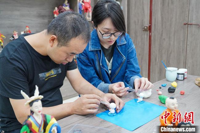 <a target='_blank'  data-cke-saved- >中新社</a>記者(右)現(xiàn)場(chǎng)體驗(yàn)面塑制作過程?！￡悹?zhēng)強(qiáng) 攝