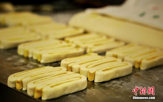 圖為面劑被涂上胡麻油，切成條狀用作月餅的花型制作。張文 攝