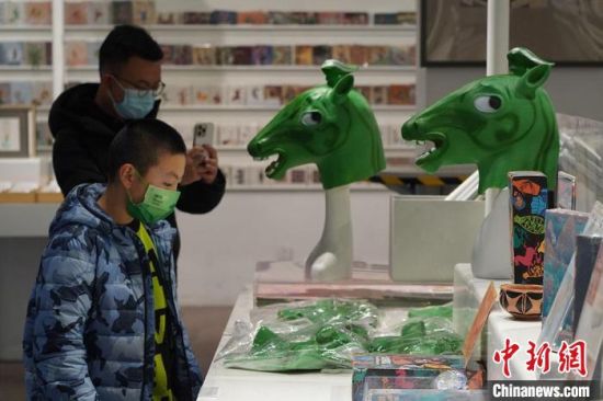 圖為“神馬來了”銅奔馬頭套吸引參觀者駐足?！【琶赖┰?攝