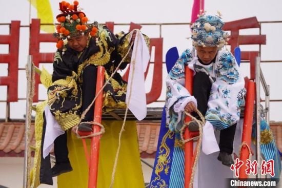 圖為“苦水高高蹺”表演者通過麻繩將腳固定在腳踏板，并在腿部纏繞六七圈?！【琶赖┰?攝