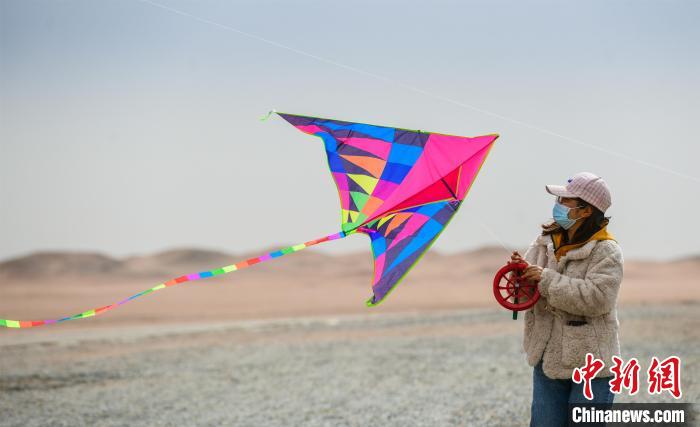 圖為市民正在陽關(guān)景區(qū)放風(fēng)箏。　王斌銀 攝