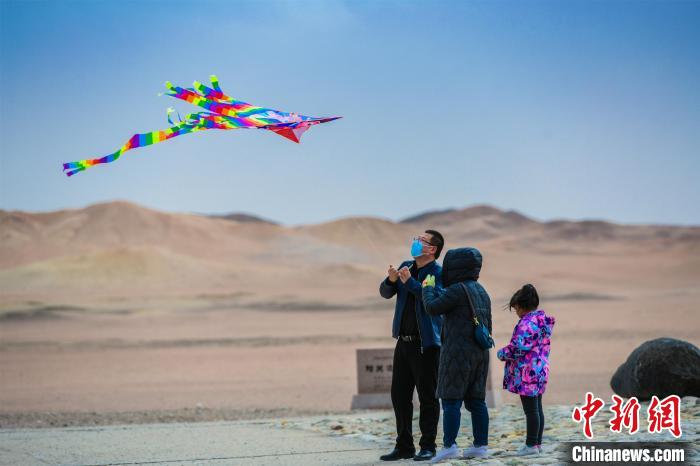 圖為市民正在陽關(guān)景區(qū)放風(fēng)箏。　王斌銀 攝