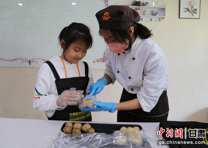 圖為在甘臺(tái)胞小朋友在工作人員指導(dǎo)下制作月餅。九美旦增 攝