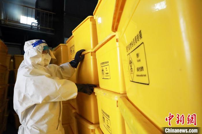 圖為工作人員搬運醫(yī)療廢物專用周轉(zhuǎn)箱?！∥航ㄜ?攝