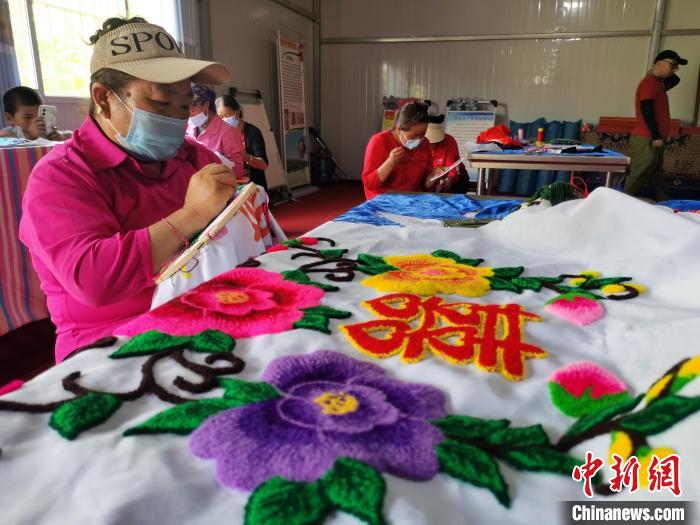 圖為婦女制作青繡?！?zhí)砀?攝