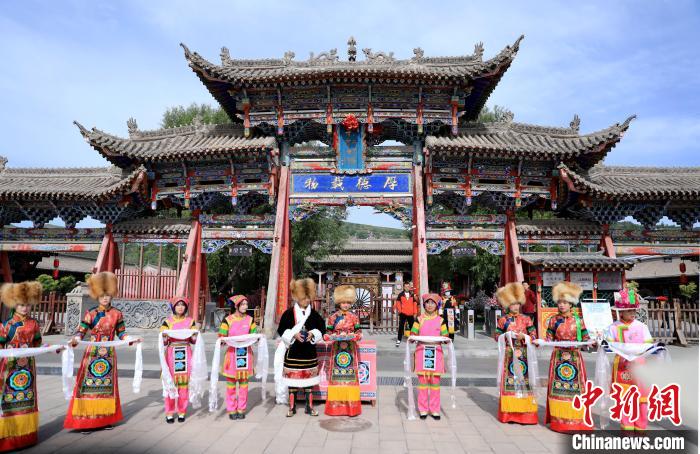 圖為身穿土族服飾的工作人員迎接訪客?！⊙Φ?攝