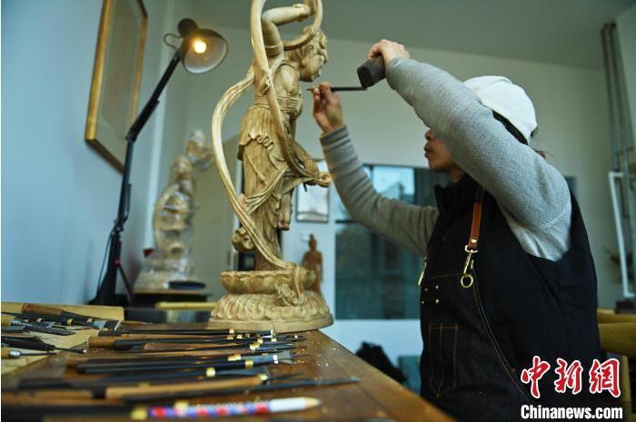 圖為季茂杰進(jìn)行敦煌元素的木雕創(chuàng)作。李亞龍 攝</p>
<p>