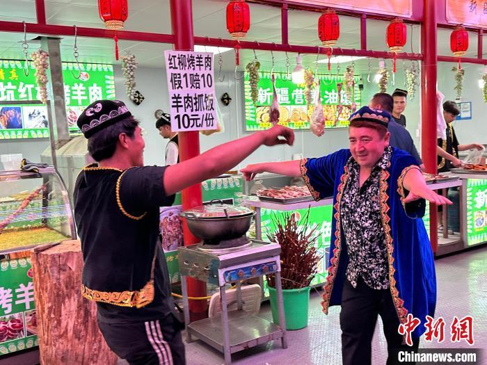 圖為餐飲經(jīng)營者在“西涼不夜城”跳起舞蹈引客。　戴文昌 攝</p><p>