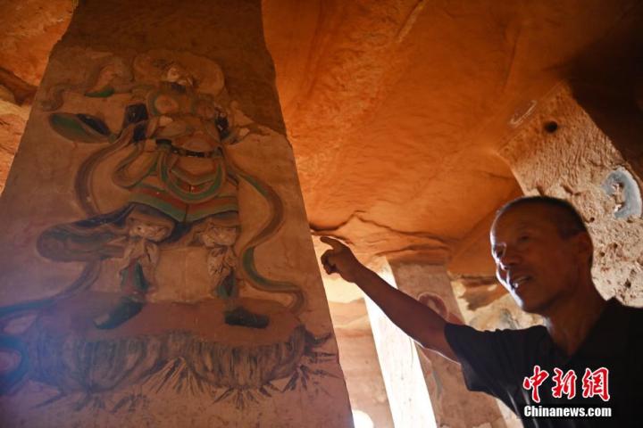 7月15日，甘肅省平?jīng)鍪袥艽h百里石窟長廊羅漢洞石窟內(nèi)，該窟文保員郭建平介紹窟內(nèi)石刻彩繪壁畫。郭建平家中三代人曾自發(fā)保護羅漢洞石窟。羅漢洞石窟遺存40余個窟龕，以北魏至清代風(fēng)格為主。中新社記者 李亞龍 攝</p>
<p>