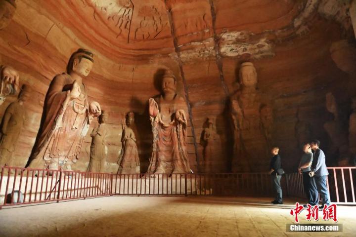 7月15日，游人參觀甘肅省平?jīng)鍪袥艽h百里石窟長廊中的南石窟寺1號窟。百里石窟長廊位于涇川縣境內(nèi)，由512個石窟、5眼窟中石井組成，現(xiàn)存王母宮石窟、鳳凰山石窟、南石窟寺、丈八寺石窟、羅漢洞石窟、太山寺石窟等規(guī)模較大的石窟群，還有數(shù)量眾多的小石窟群。南石窟寺開鑿于北魏永平三年，其中1號窟屬于大型七佛窟，七佛高達6米。中新社記者 李亞龍 攝