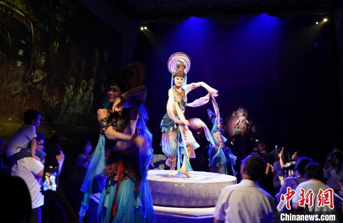 《樂動敦煌》是全球首部洞窟式沉浸體驗劇，利用真人與數(shù)字影像虛實交換實現(xiàn)沉浸式體驗。圖為2023年8月28日晚，《樂動敦煌》演出。(資料圖)中新社記者 毛建軍 攝