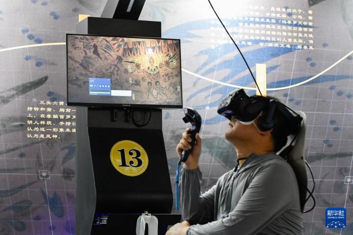 7月22日，游客借助VR設(shè)備沉浸式游覽莫高窟第285窟虛擬場景。新華社記者 郎兵兵 攝